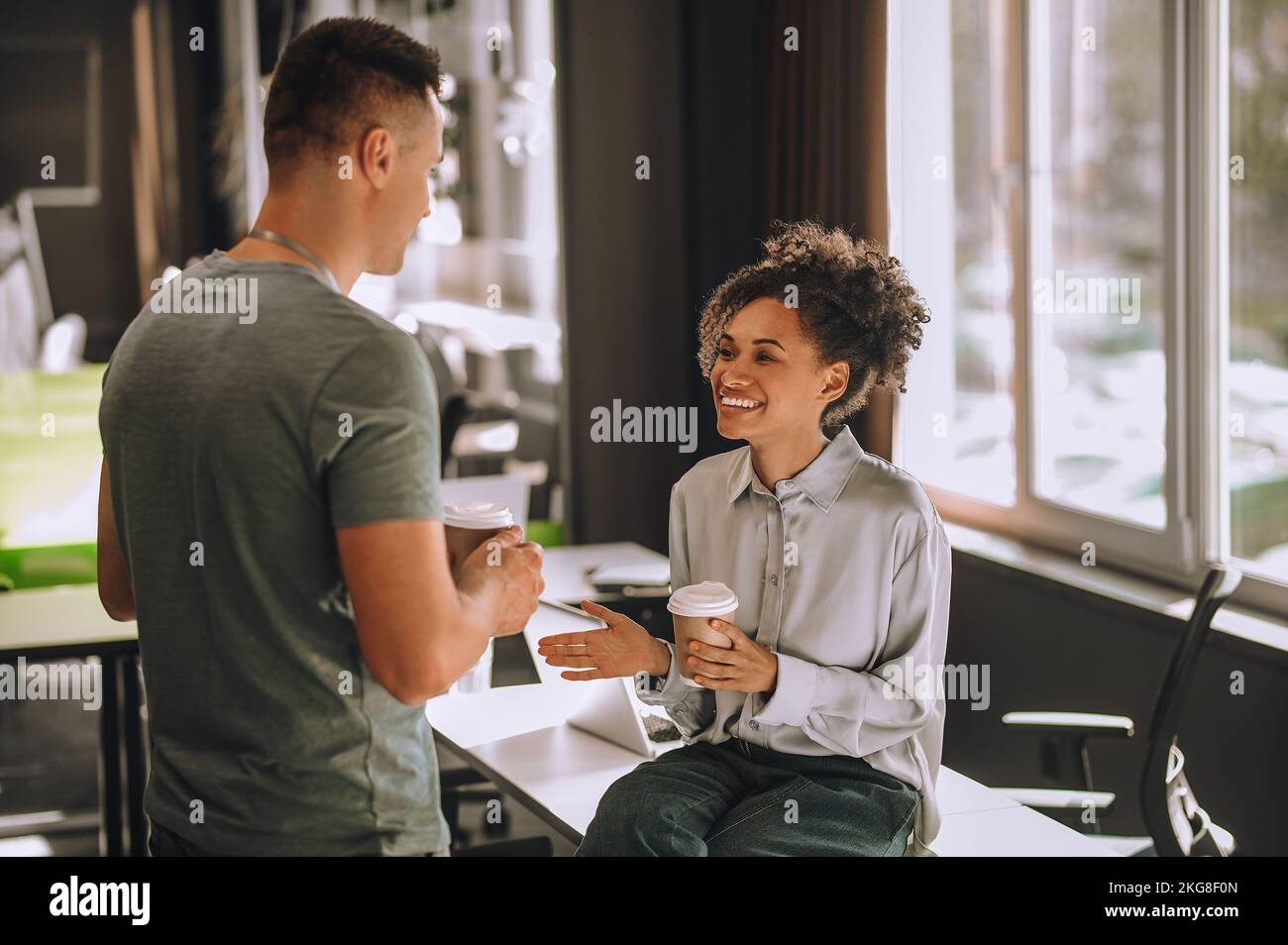 Une employée de bureau joyeuse communique avec son collègue Banque D'Images