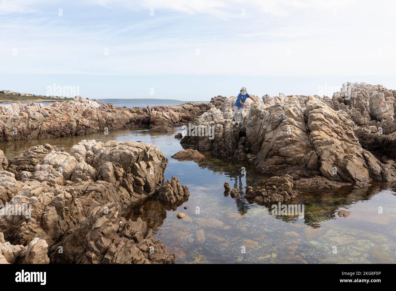 Afrique du Sud, Gansbaai, Boy (8-9) escalade sur des rochers sur la côte maritime Banque D'Images