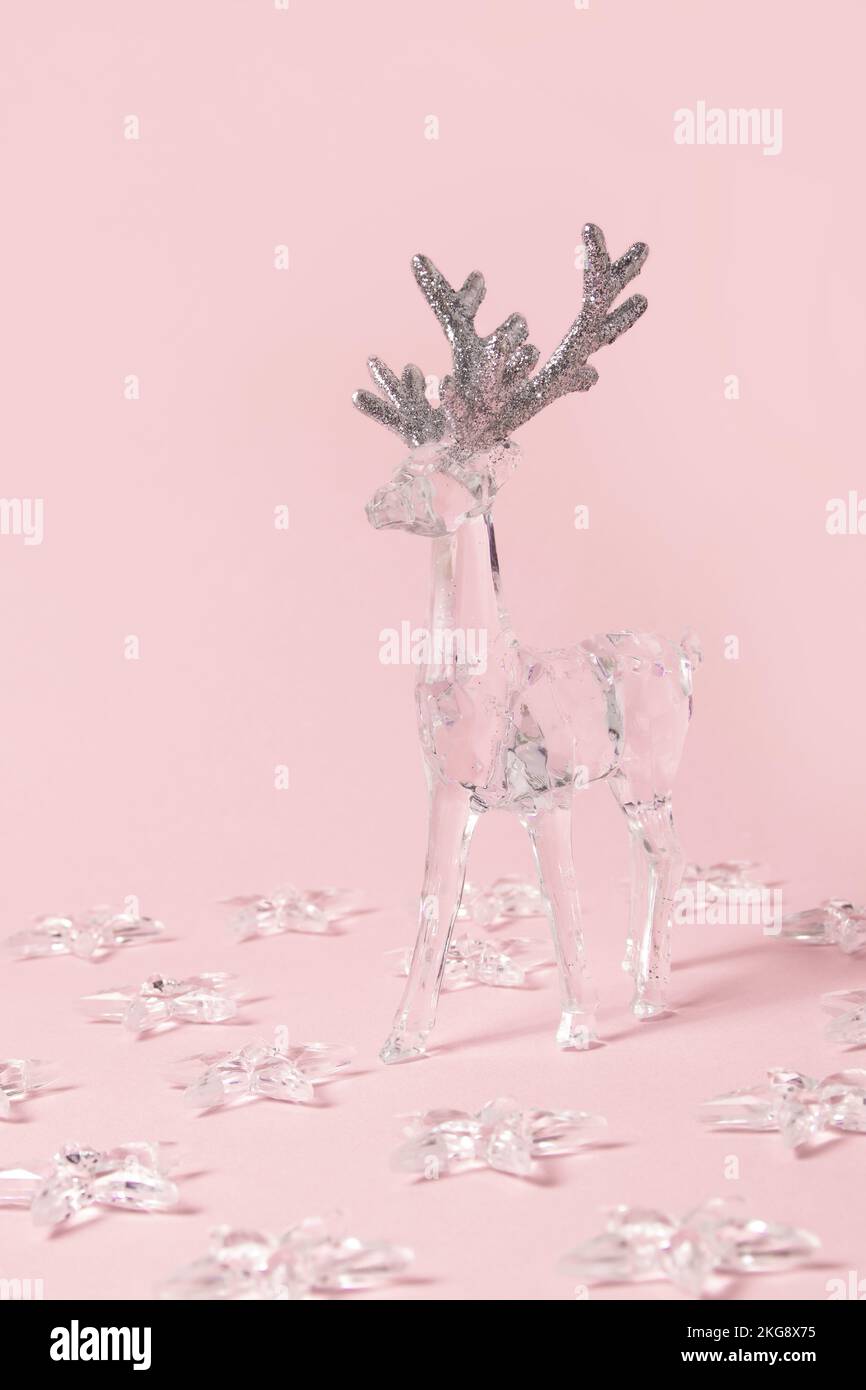 Renne transparent et étoiles sur fond rose pastel. Concept minimal de Noël ou de nouvel an. Banque D'Images