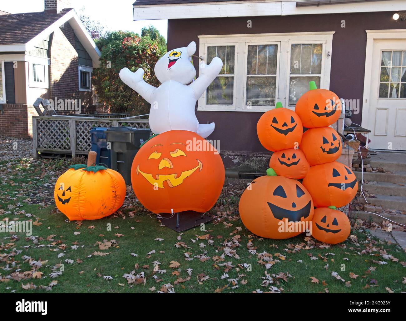 Un groupe joyeux de Jack-o'-lanternes d'Halloween et un fantôme de soufflage décorent une cour de quartier. Fergus Falls Minnesota MN États-Unis Banque D'Images