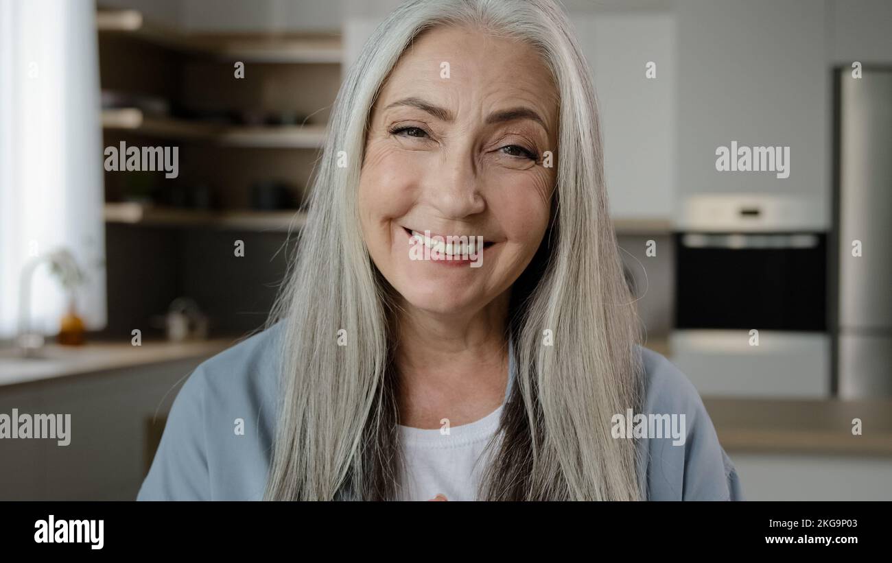 Positive vieille femme retraité regarder la webcam heureux 70s granny appeler en ligne chat vidéo distant avec la famille en quarantaine temps virtuel Internet Banque D'Images