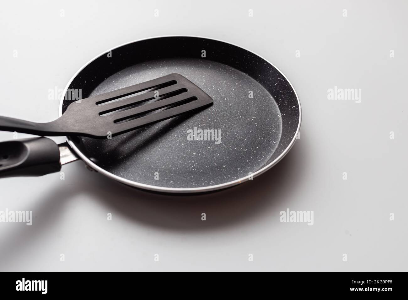 Vider le récipient sur fond blanc. Poêle à frire avec spatule Banque D'Images