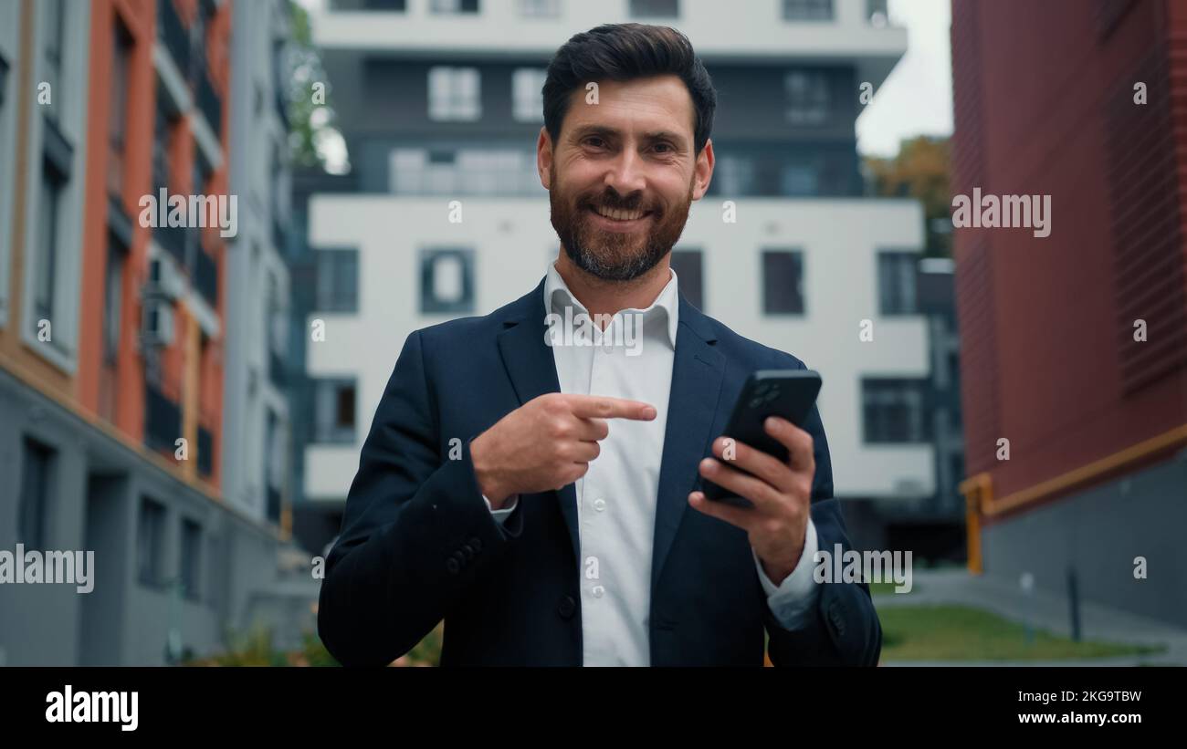 Homme d'affaires réussi homme caucasien barbu Manager employé utiliser Internet ville wifi chat messages en ligne point doigt sur la fabrication moderne de téléphone Banque D'Images