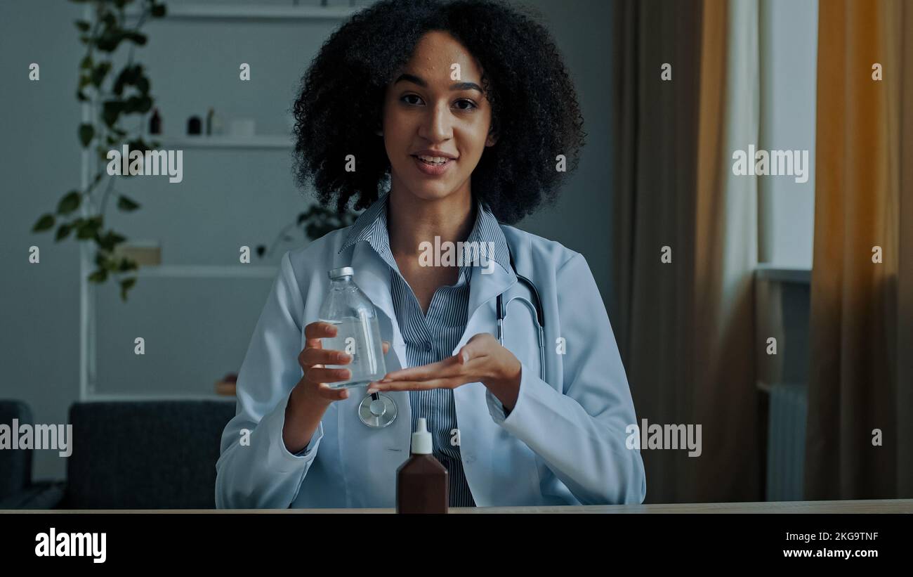 African médecin ethnie femme intern médecin thérapeute pharmacien médecin tenir le flacon de médicament recommandant le sirop médicament publicité anesthésique Banque D'Images