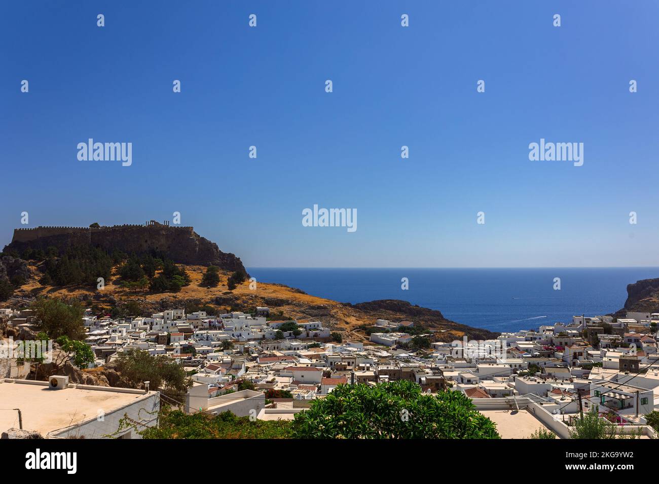 Vue panoramique sur le port coloré du village de Lindos et de l'Acropole, Rhodes. Vue aérienne du paysage magnifique, des ruines antiques, de la mer avec des voiliers et de la côte de l'île de Rhodes en mer Egée Banque D'Images