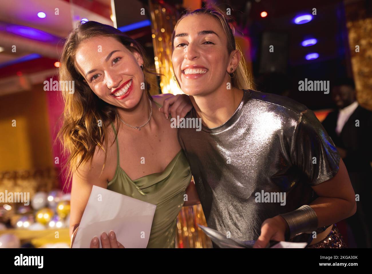 Portrait de deux amies caucasiennes dans une boîte de nuit souriant à l'appareil photo Banque D'Images
