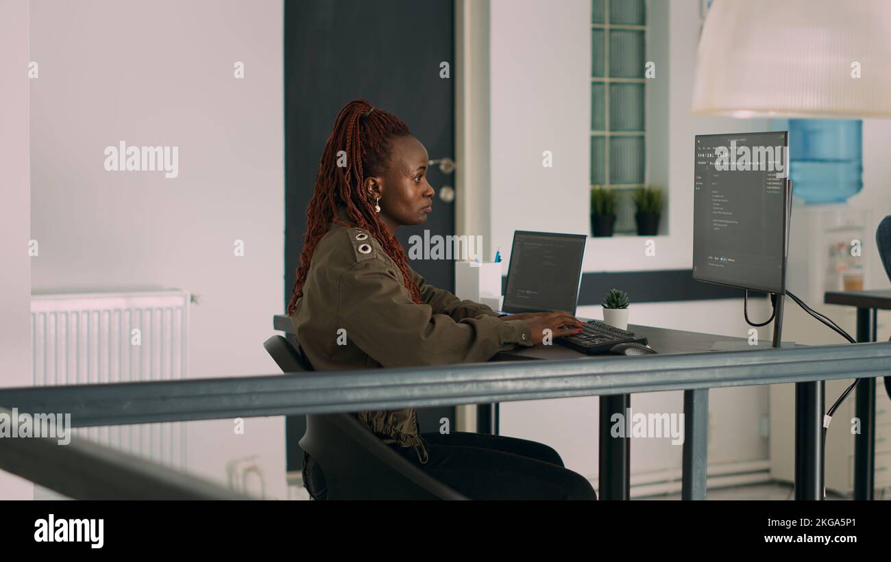 Le programme de base de données écrit le code source et le script sur la fenêtre du terminal, en travaillant avec l'ordinateur affichant l'algorithme de codage. Développeur de logiciels programmant des Big Data dans un bureau d'agence. Banque D'Images