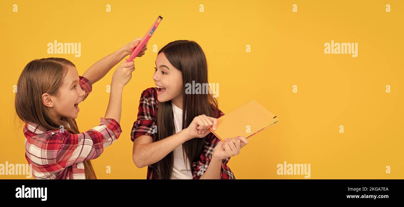 Filles d'école amis. Enfants gaies dans décontracté damier chemise ayant le plaisir avec des blocs-notes, meilleur ami. Bannière de l'école fille étudiante. Écolière Banque D'Images