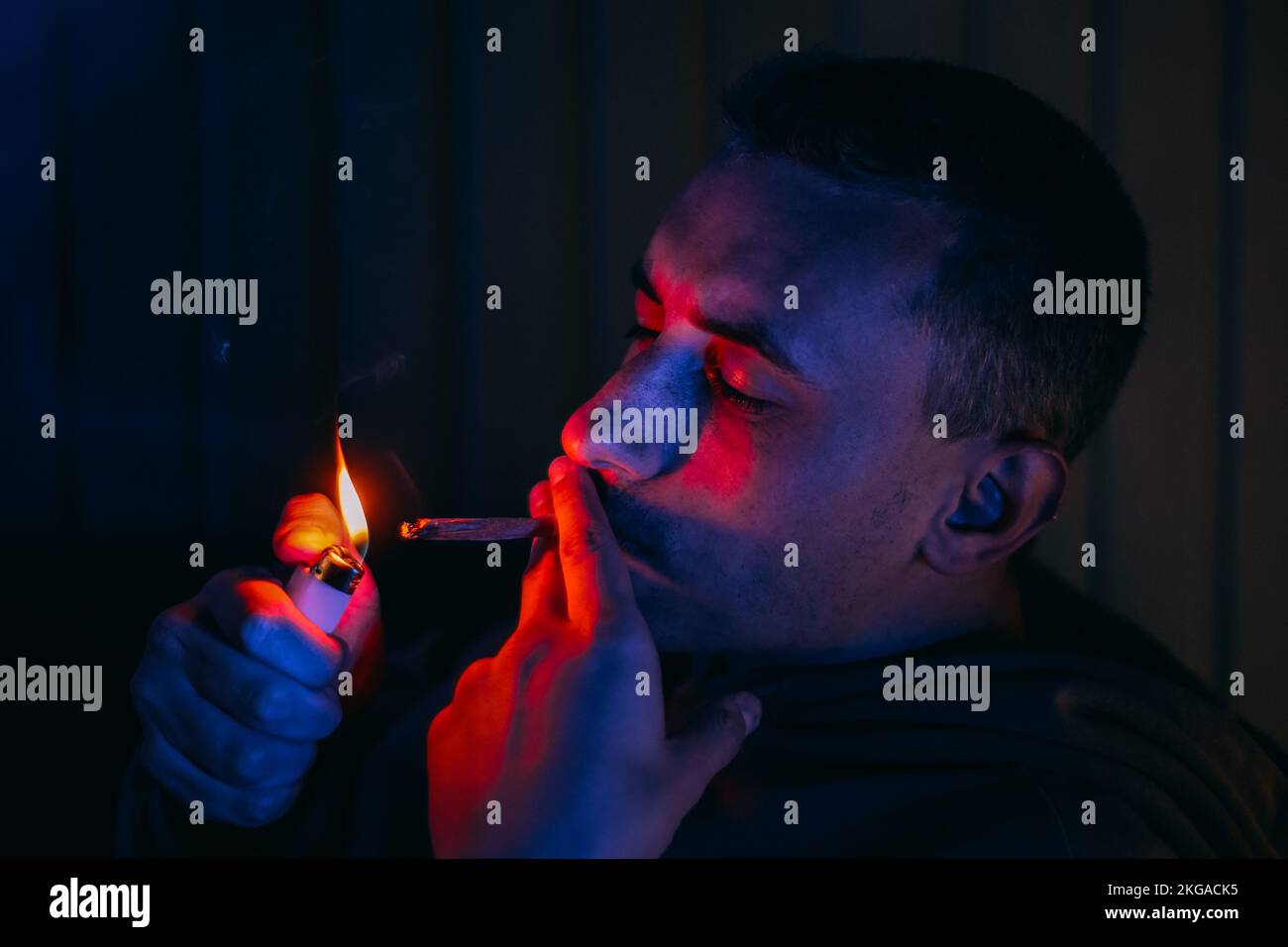 Portrait d'un homme au néon qui fume un joint. Guy fume joint, marijuana, drogues cbd et thc Banque D'Images