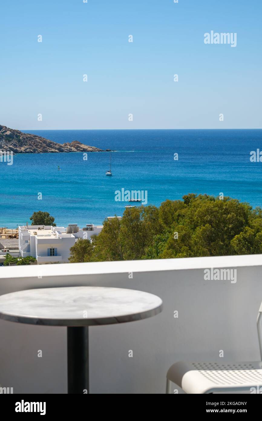 Vue incroyable depuis un balcon avec une chaise et une table donnant sur la célèbre plage Mylopotas à iOS Grèce Banque D'Images