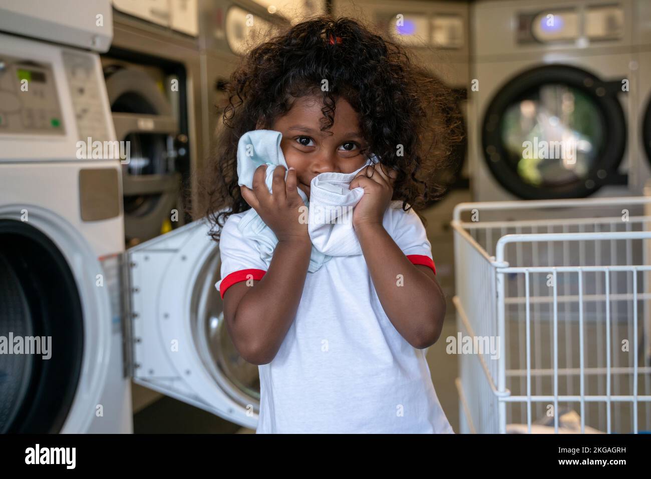 Enfant calme jouant dans une laverie automatique publique Banque D'Images