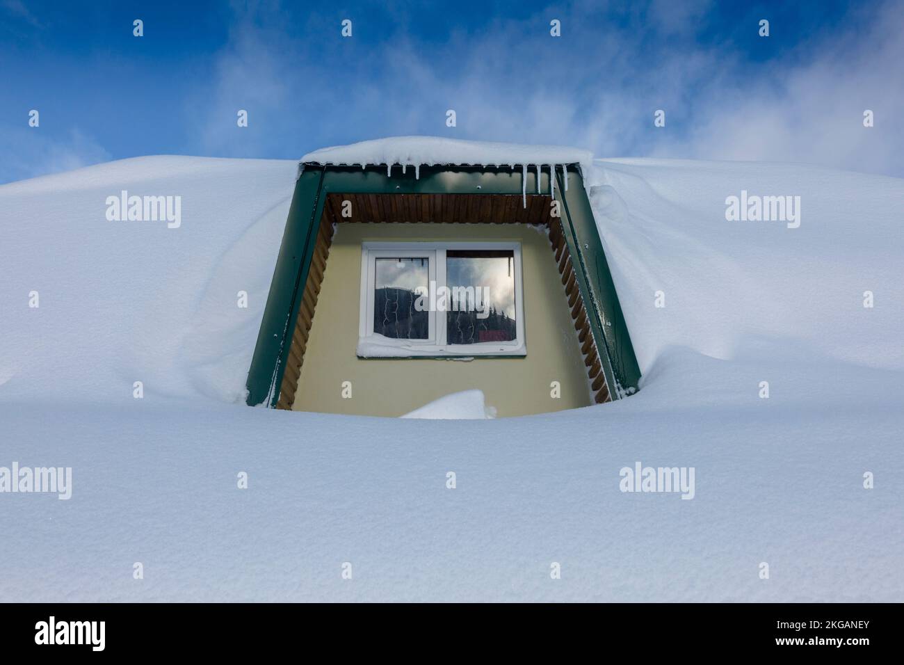 Petite fenêtre de la cabane de montagne couverte de neige blanche fraîche, un conte de fées blanc d'hiver Banque D'Images