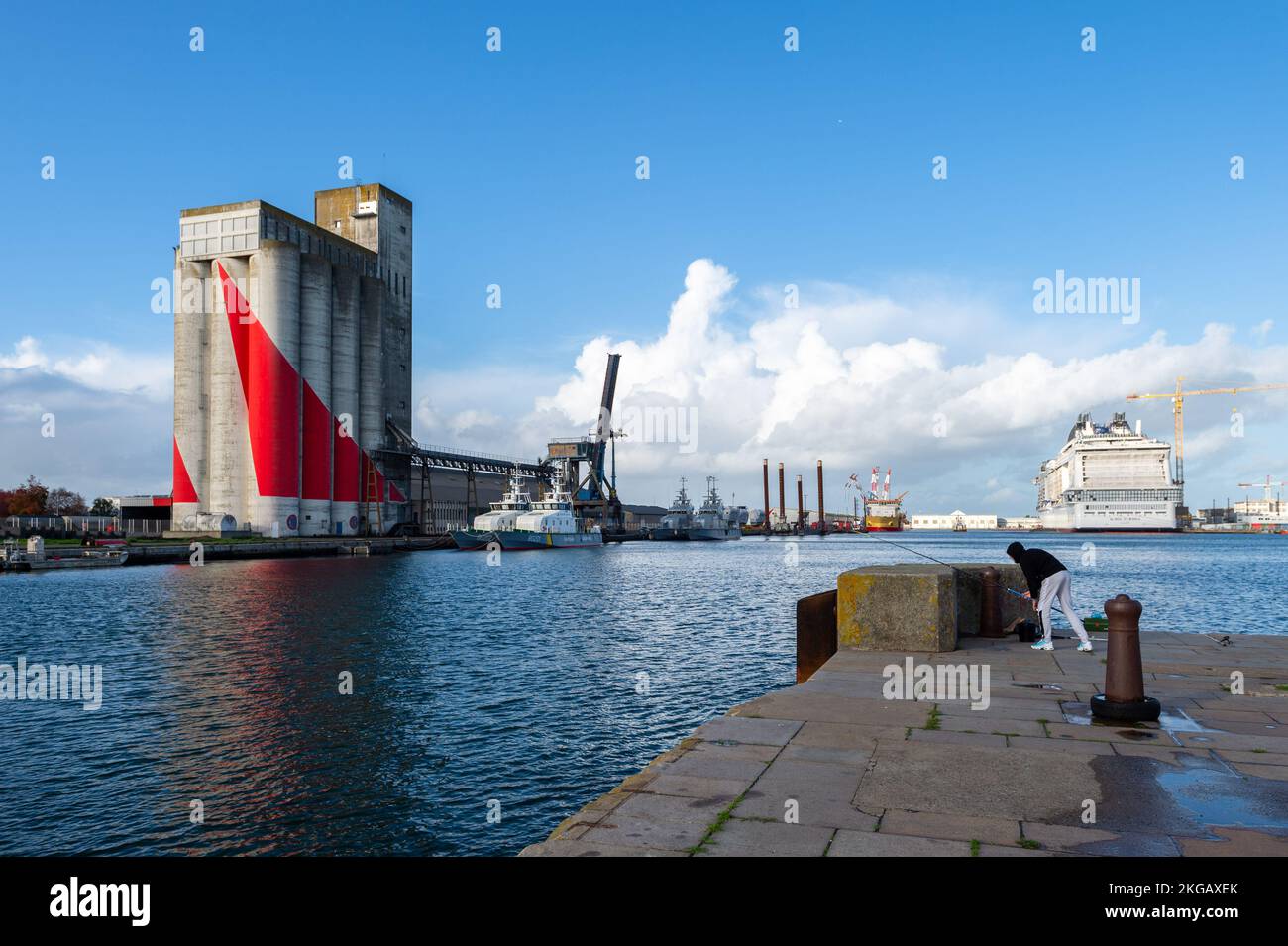 Le silo de céréales rouge et blanc dans le port de Saint-Nazaire. Les chantiers maritimes de l'Atlantique à Saint-Nazaire (France) construisent un nouveau navire de croisière pour la société italienne-suisse MSC équipé de technologies durables. Nommé MSC EURIBIA, ce navire est alimenté par du GNL sans émettre d'oxydes de soufre (SOx) et réduit de 85 % les oxydes d'azote (NOx). Il n'émet pas de particules fines et réduit les émissions de gaz à effet de serre de 20 %. Les navires de croisière sont de plus en plus critiqués dans les ports où ils se mettent à quai pour leur pollution. (Photo de Laurent Coust/SOPA Images/Sipa USA) Banque D'Images