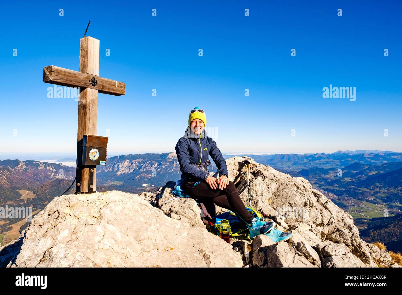 Mountaineer faisant une pause au sommet de la croix de Schärtenspitze, Hochkalter, Alpes de Berchtesgaden, Parc national de Berchtesgaden, Ramsau, Berchtesgad Banque D'Images