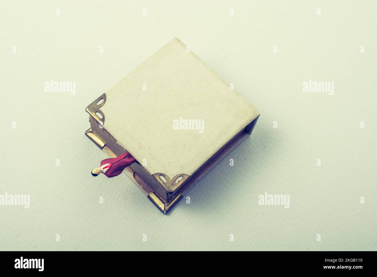 Figurine minuscule de l'homme modèle trouvé à côté d'un livre Banque D'Images