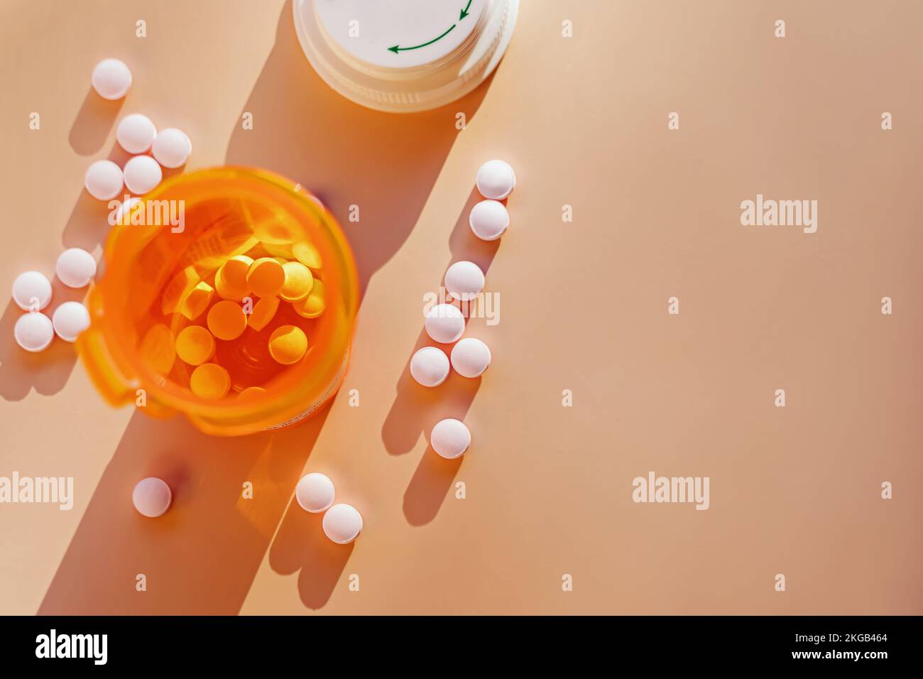 Vue de dessus des pilules et bouteille d'orange en plastique pour les médicaments prescrits, de longues ombres, lumière naturelle Banque D'Images
