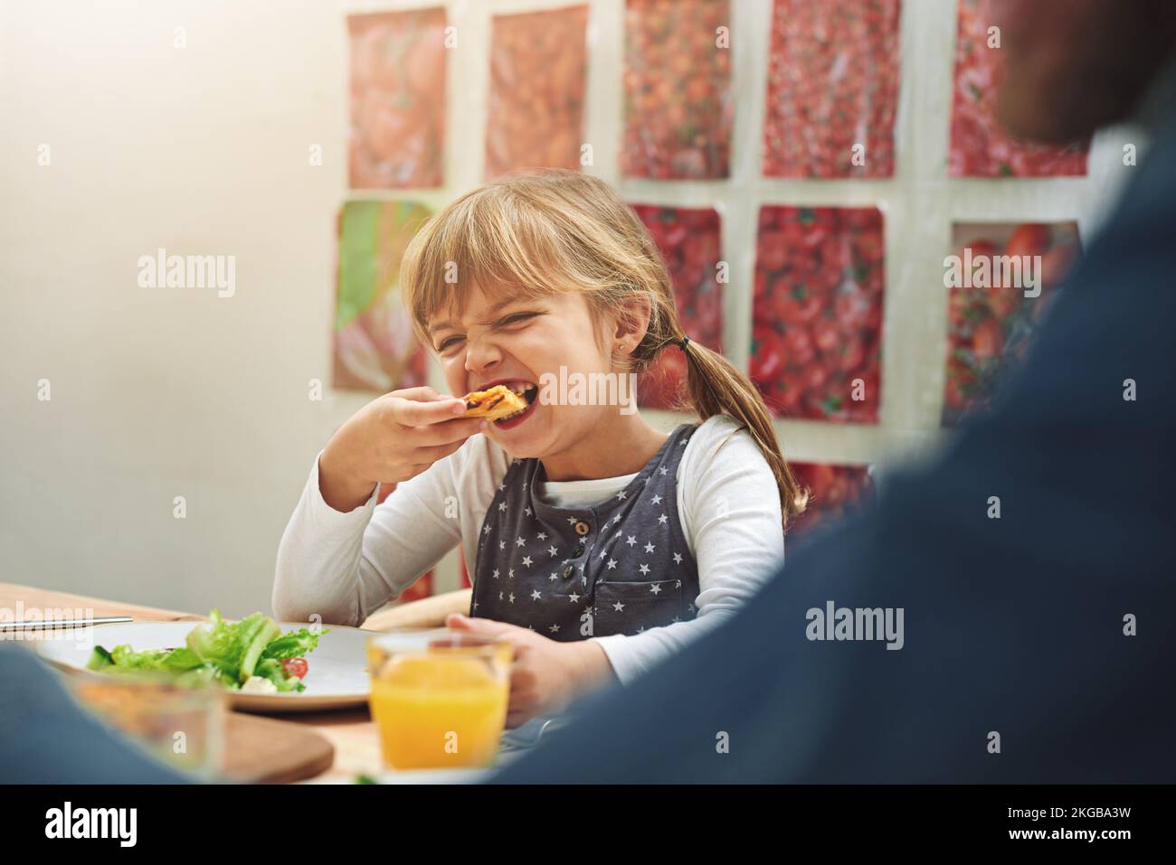 Je viens juste ici pour la pizza. une famille savourant une pizza à la maison. Banque D'Images