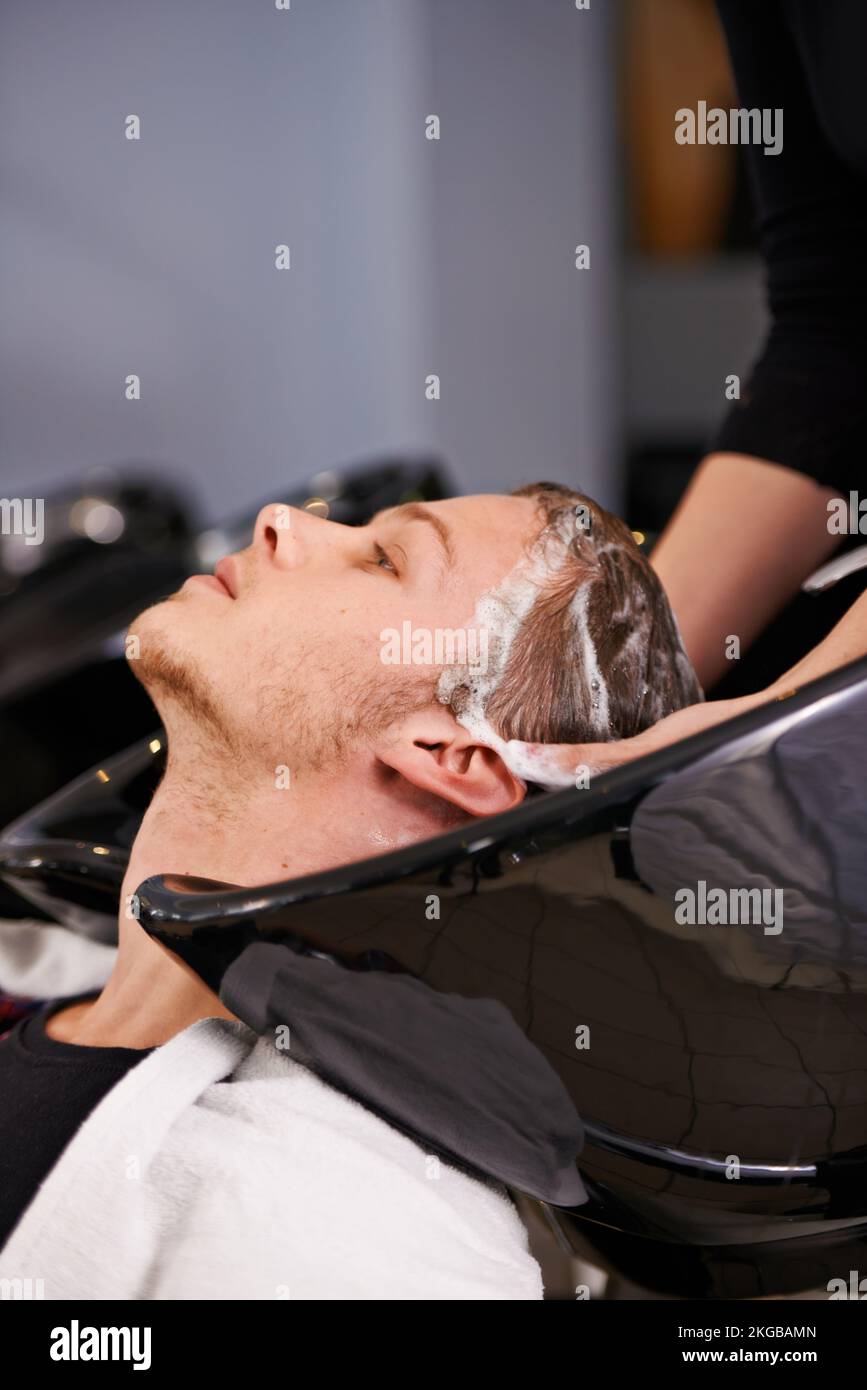 Le paradis du shampooing. un jeune homme ayant lavé ses cheveux dans un salon de coiffure. Banque D'Images