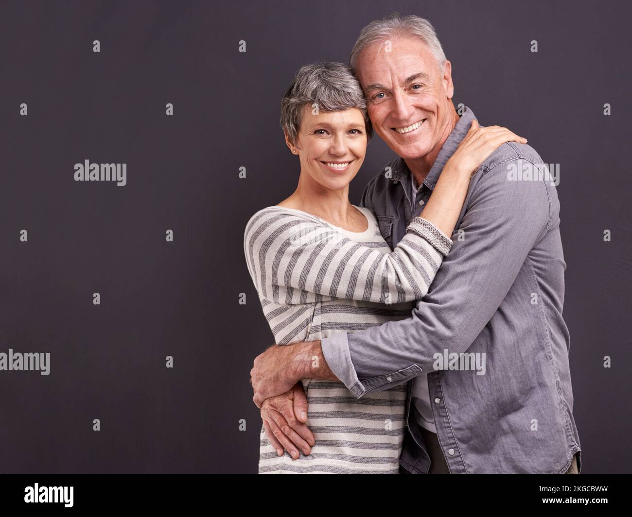 Leur amour est aussi fort que jamais. Portrait studio d'un couple affectueux et âgé sur fond gris. Banque D'Images