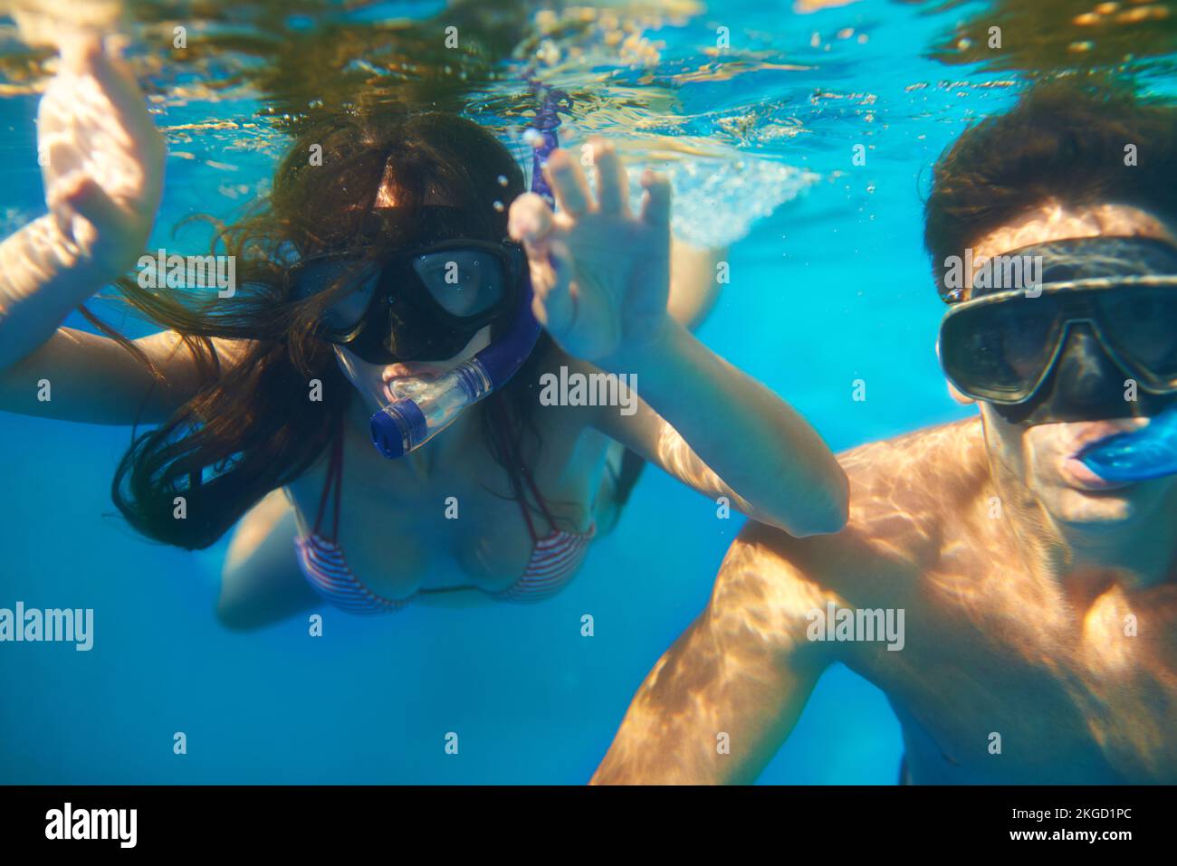 Enlisée dans la beauté aquatique. un jeune couple snorkeling dans l'eau turquoise. Banque D'Images