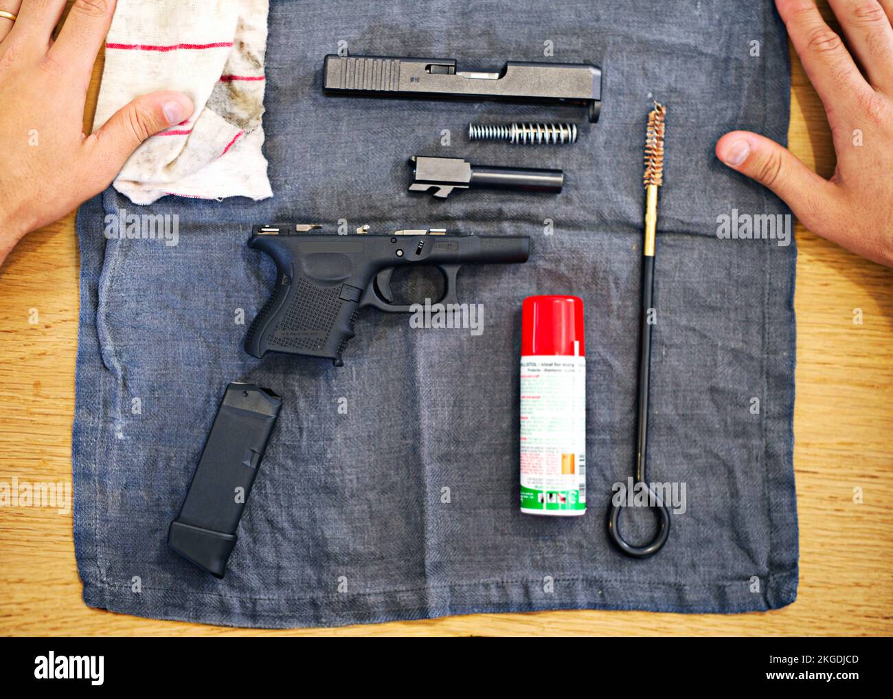 Outils essentiels pour chaque propriétaire de pistolet. Un cliché d'un pistolet démonté reposant sur un plan d'examen. Banque D'Images