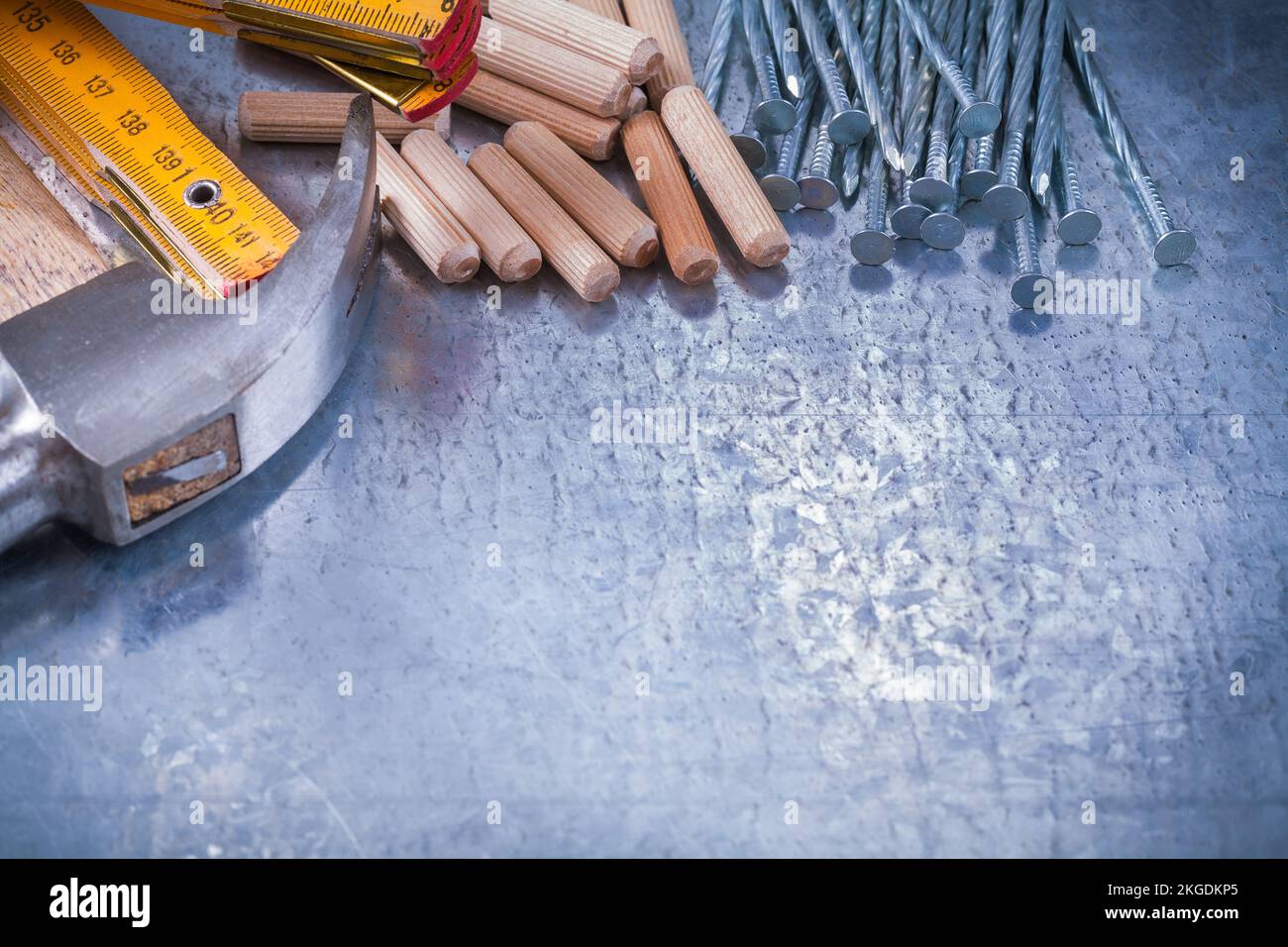 Marteau à griffes construction de compteur en bois clous et chevilles sur fond métallique rayé concept d'entretien. Banque D'Images