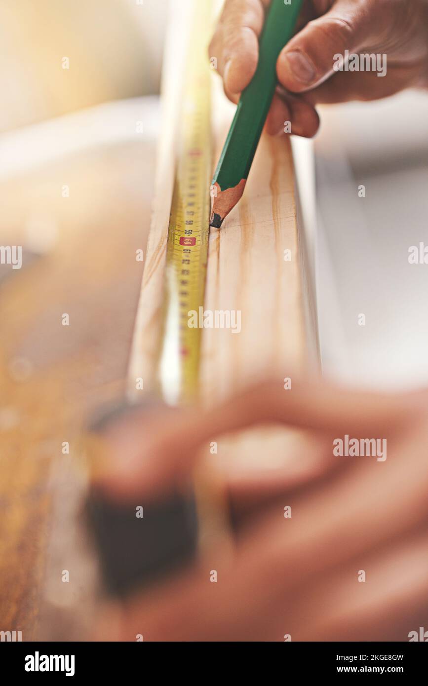 Il n'y a pas de place pour l'erreur ici. un charpentier faisant des mesures sur une planche de bois. Banque D'Images