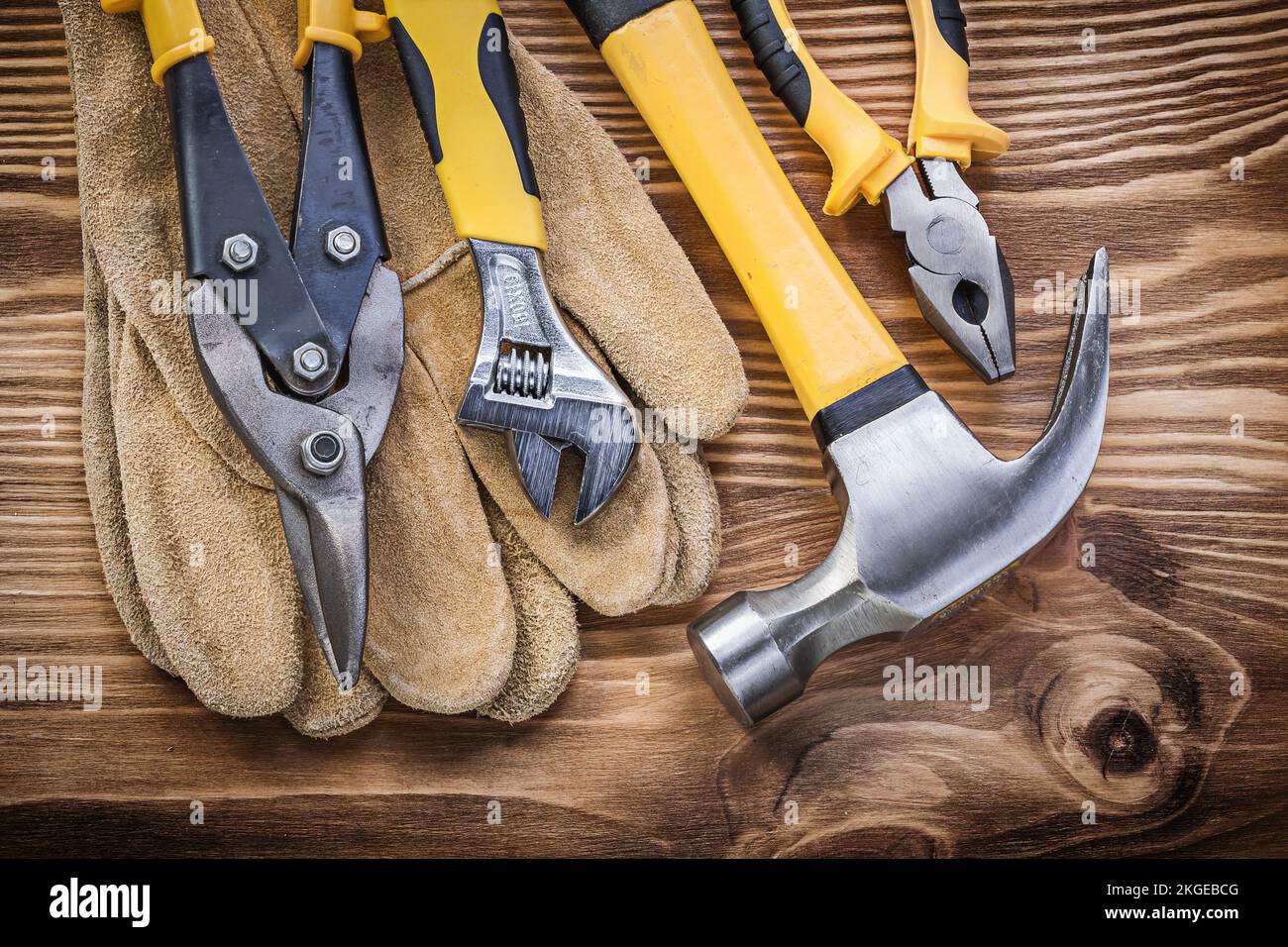 Gants de sécurité en cuir pince pour marteau à griffes clé réglable en acier sur panneau en bois. Banque D'Images