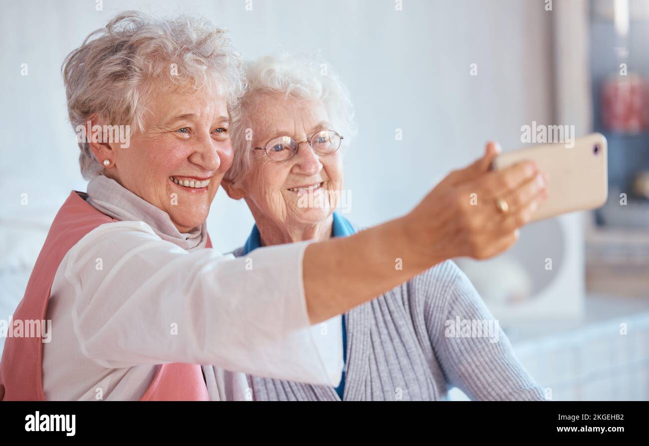 Téléphone, selfie et amis âgés sourient pour les photos à partager sur les réseaux sociaux en ligne tout en se relaxant à la retraite. Des femmes heureuses, amoureuses et âgées Banque D'Images