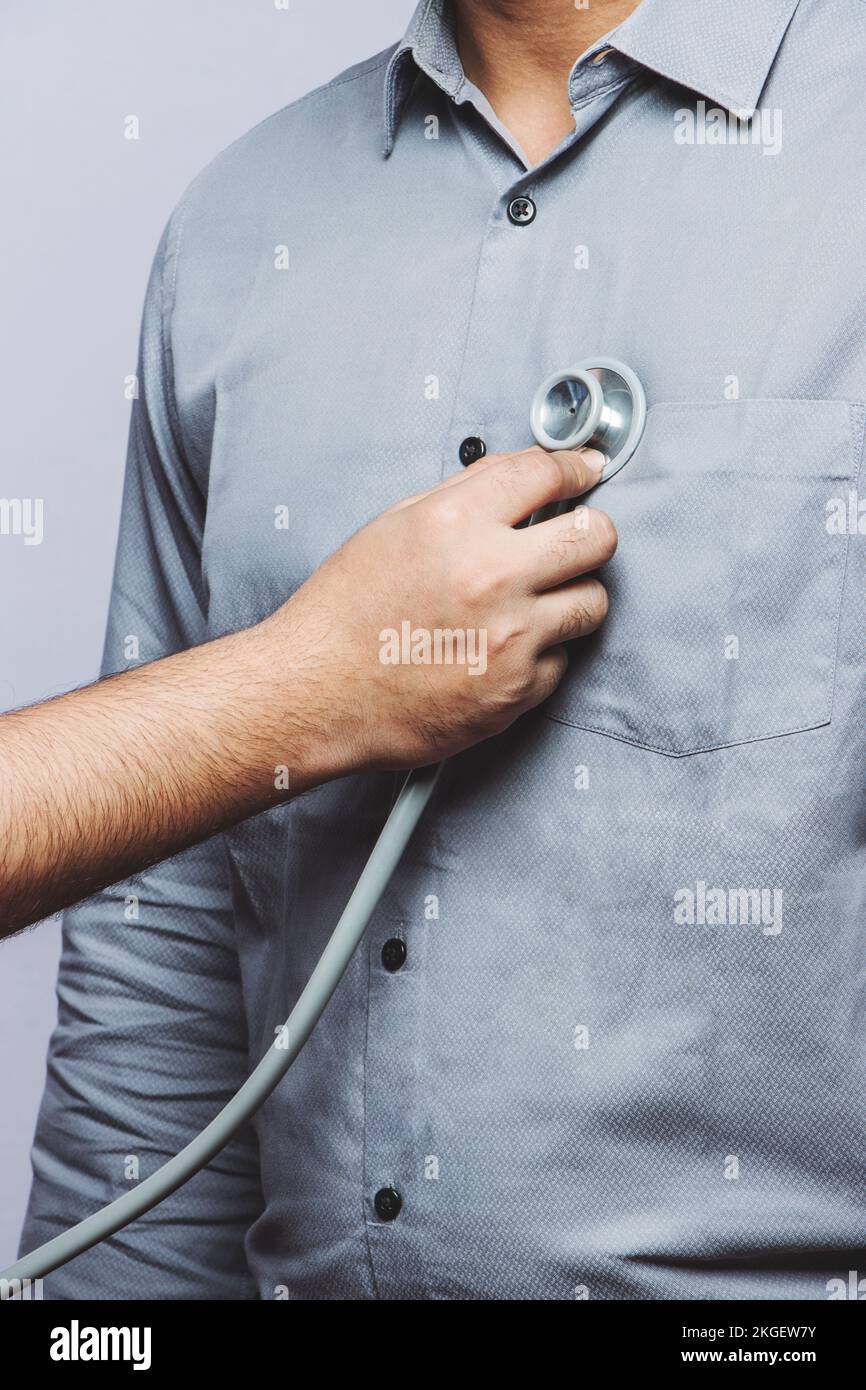 Photo haute résolution du bilan médical de routine. Gros plan d'un médecin examinant la poitrine vitale du patient avec le stéthoscope. Entretien courant. Banque D'Images
