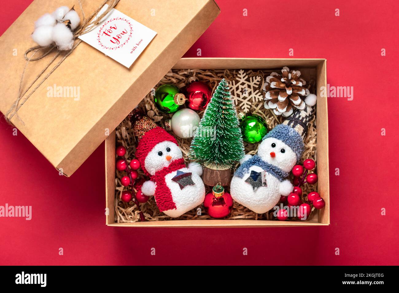 Forfait soin fait à la main, boîte cadeau de saison avec jouets, décoration de Noël sur table rouge panier écologique personnalisé pour famille, amis, fille pour le 24 décembre Banque D'Images