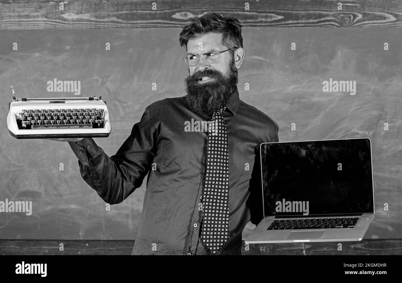 Choisissez la bonne méthode d'apprentissage. Numérique contre rétro. Les technologies modernes en bénéficient. Moderne au lieu de désuet. Boxer boxeur pour enseignants tient une machine à écrire Banque D'Images