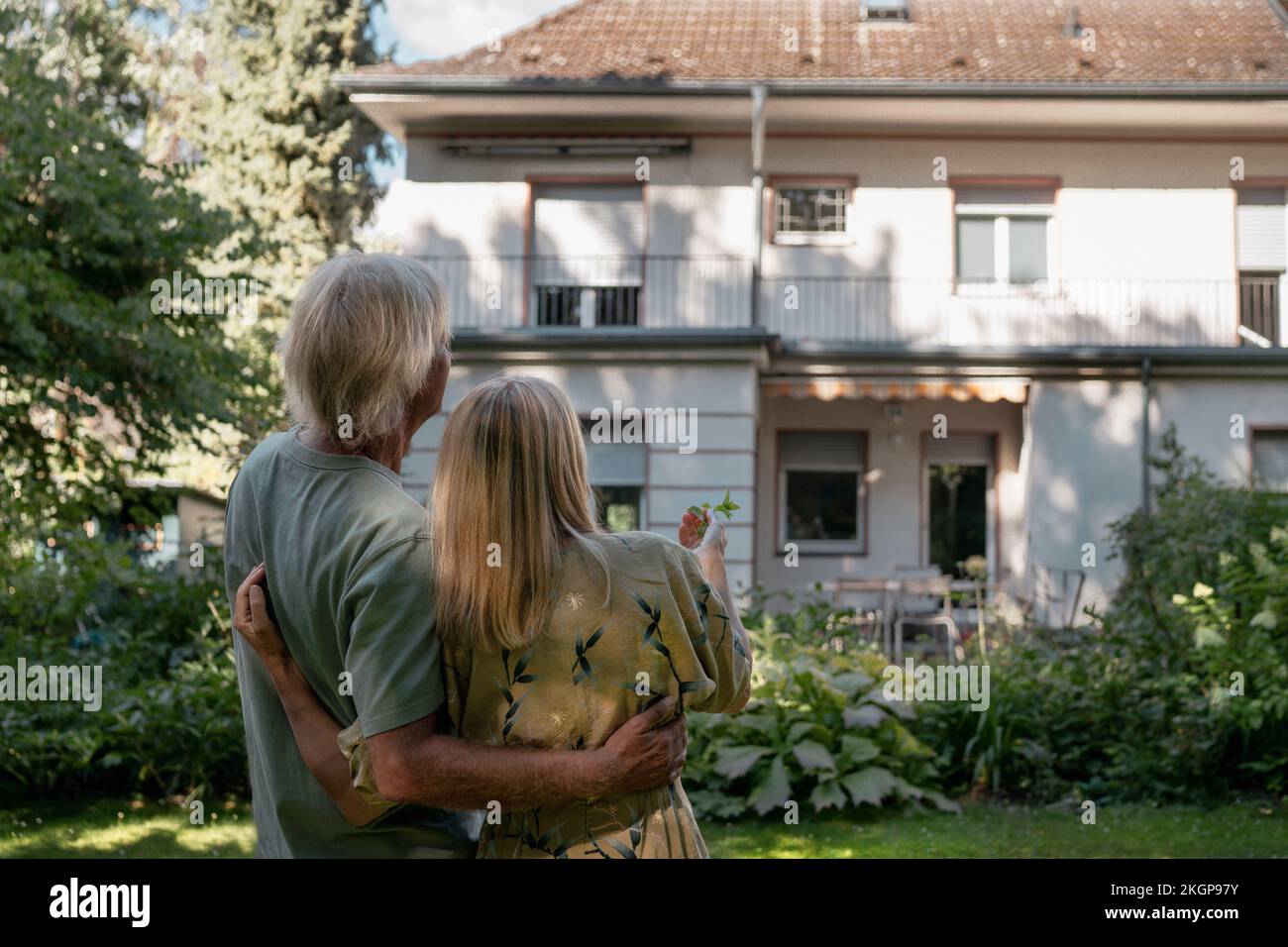 Couple debout en regardant la maison Banque D'Images