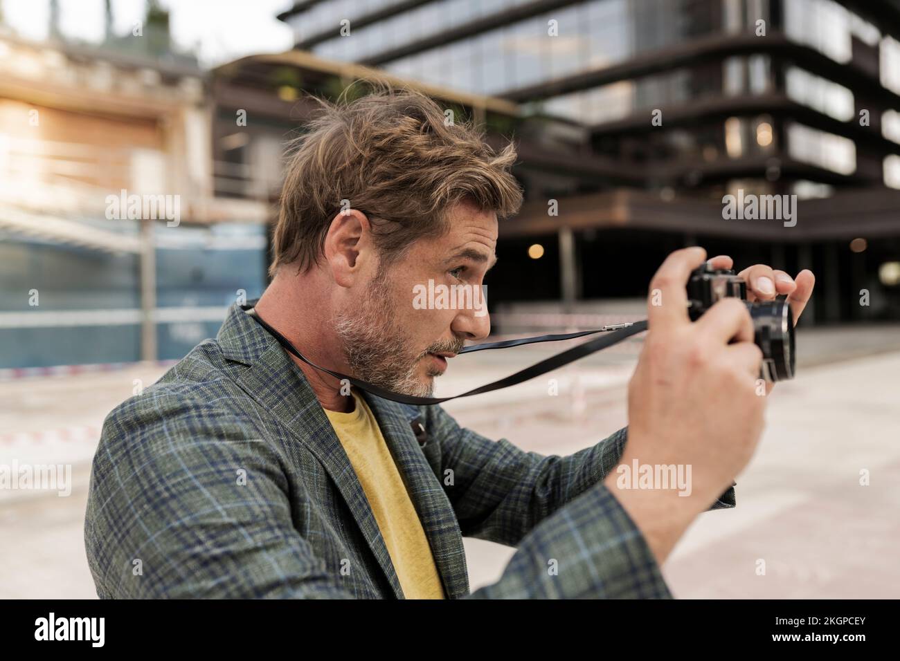 Homme prenant des photos à partir d'un appareil photo en ville Banque D'Images