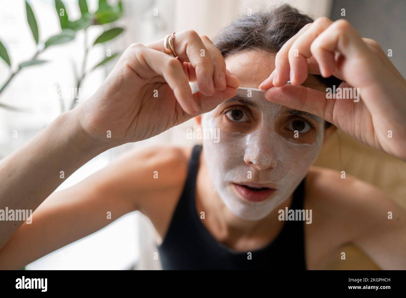 Femme qui se détache du masque à la maison Banque D'Images