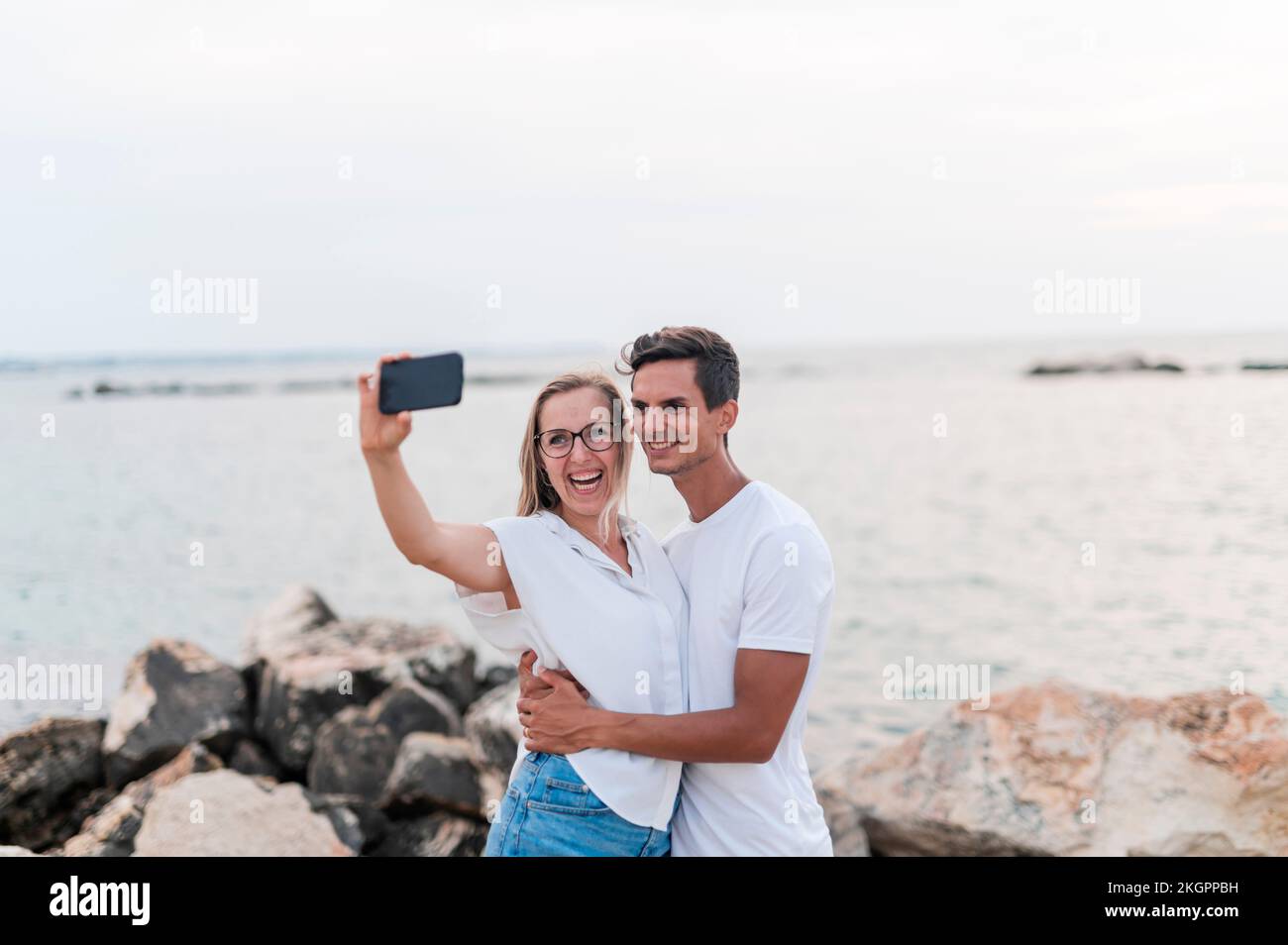 Couple heureux de prendre selfie sur téléphone portable à la plage Banque D'Images