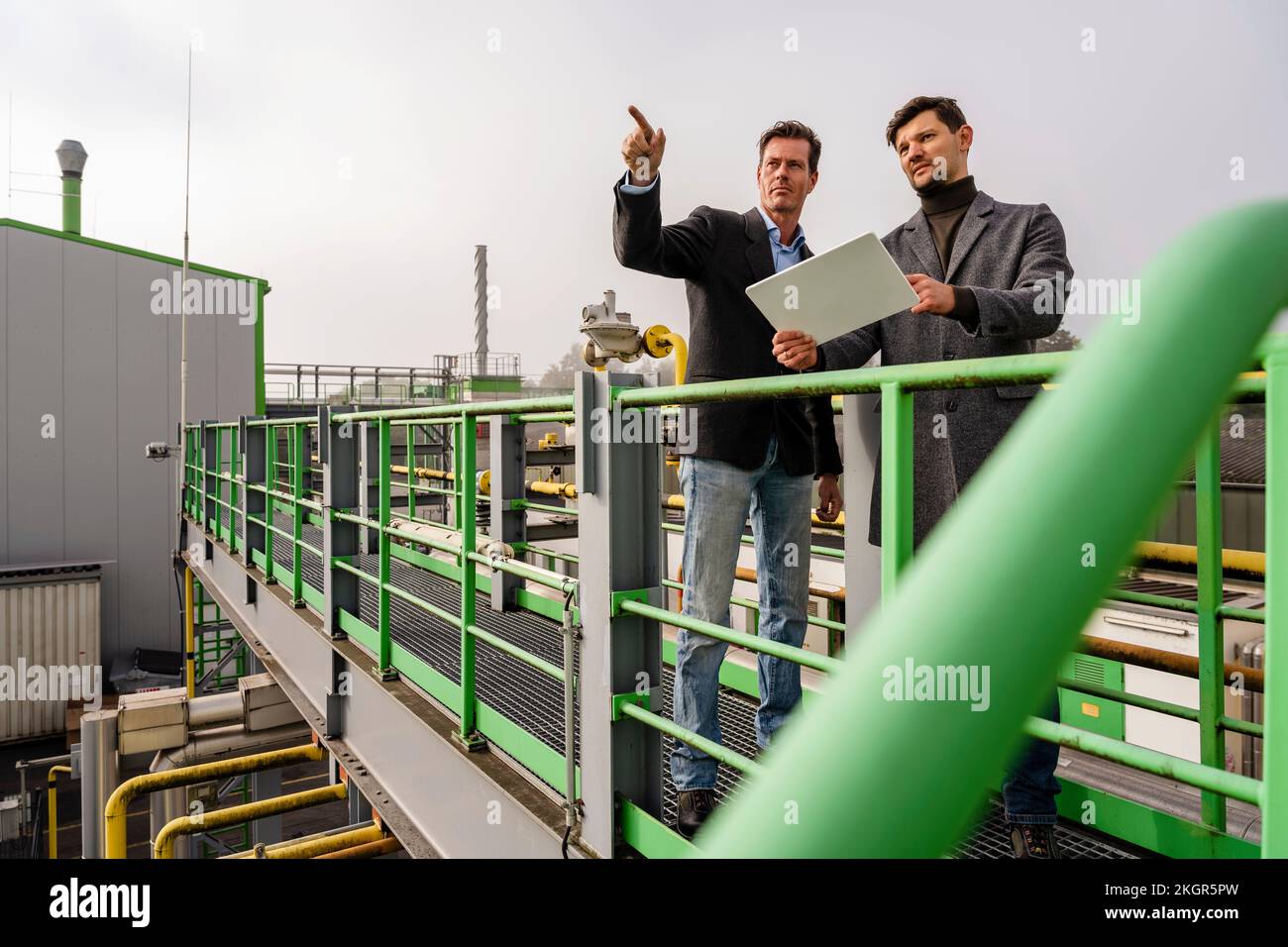 Hommes d'affaires en discussion à l'usine de recyclage Banque D'Images