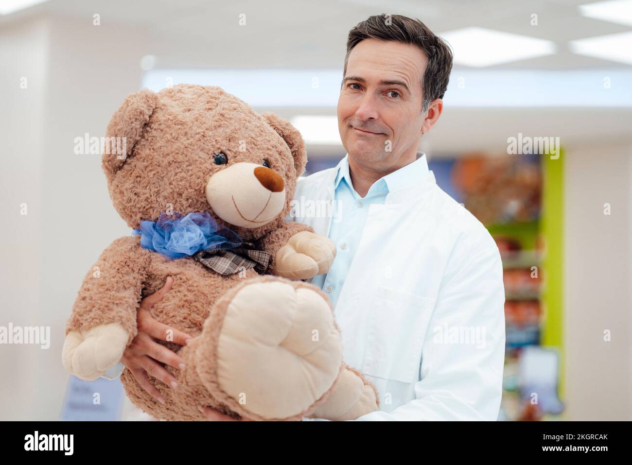 Pharmacien portant un ours en peluche à la pharmacie Banque D'Images