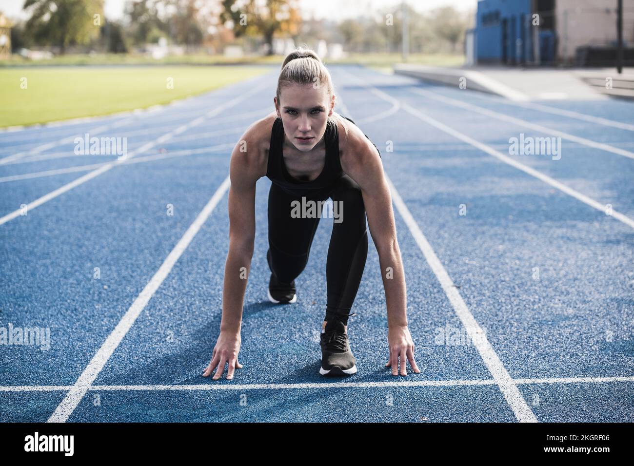 Jeune sportswoman à la ligne de départ de la piste Banque D'Images