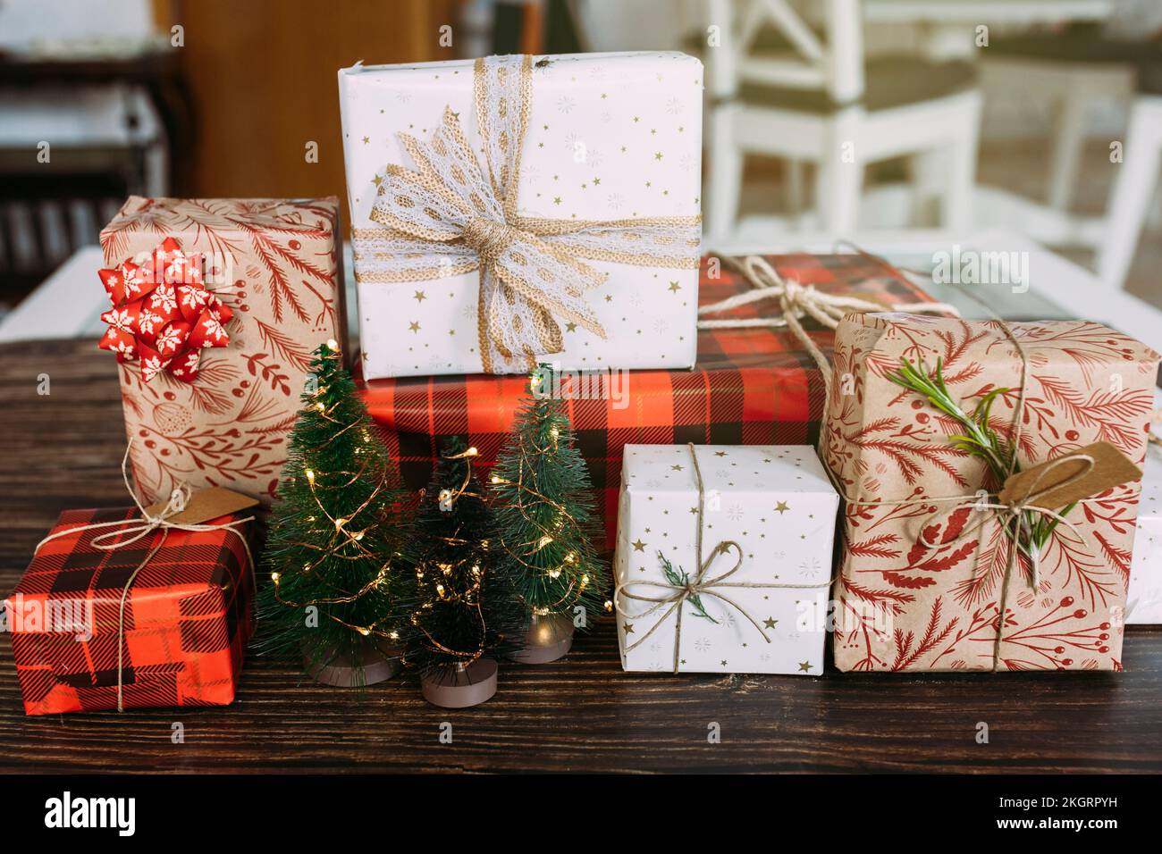 Cadeaux de Noël emballés et petits arbres disposés sur une table Banque D'Images