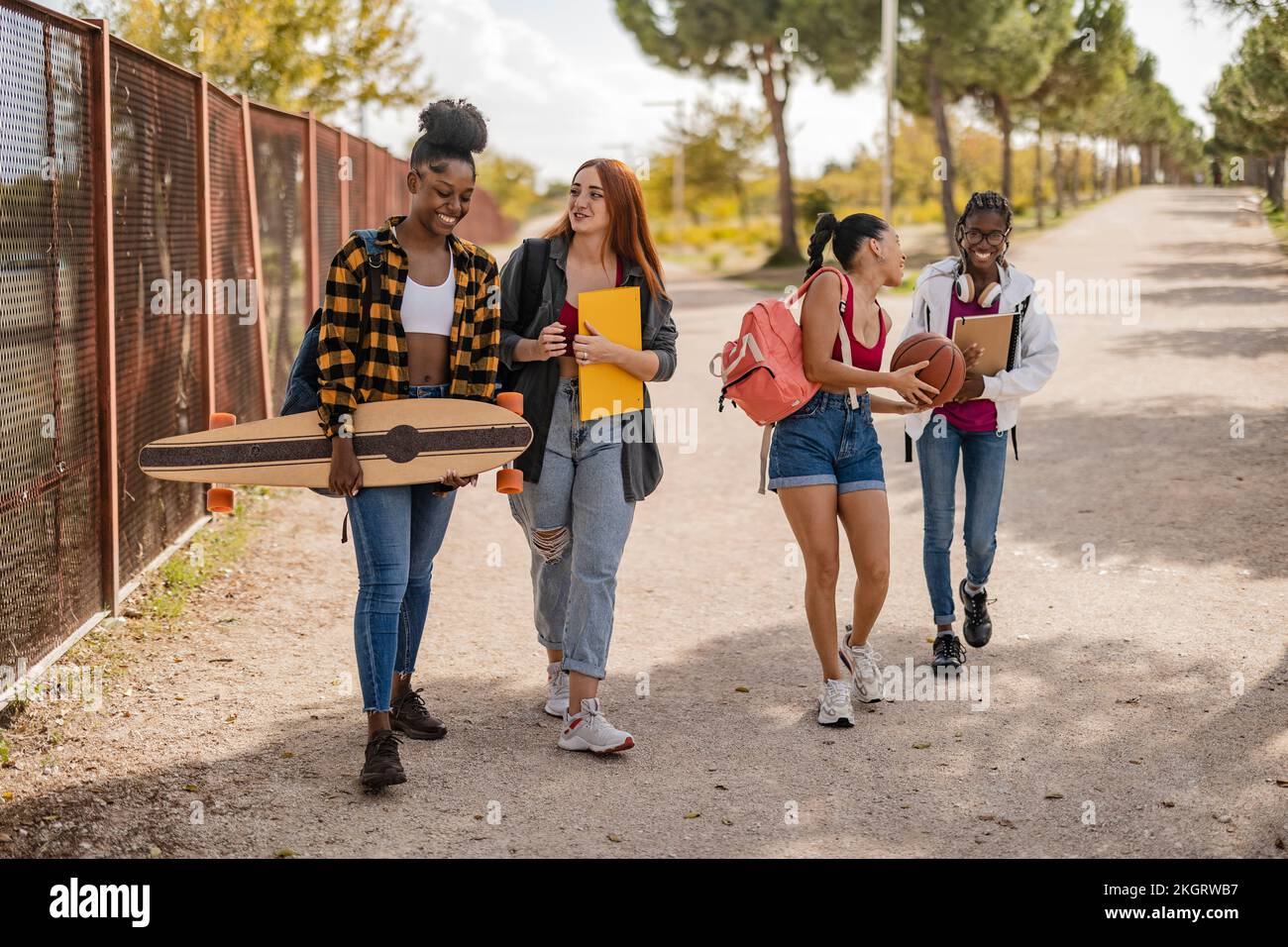 Des amis heureux qui marchent ensemble sur la route Banque D'Images Des amis heureux qui marchent ensemble sur la route Banque D'Images