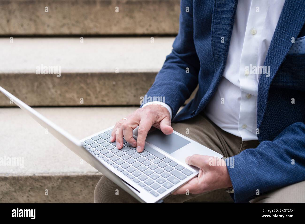 Homme d'affaires utilisant un ordinateur portable assis sur un escalier Banque D'Images