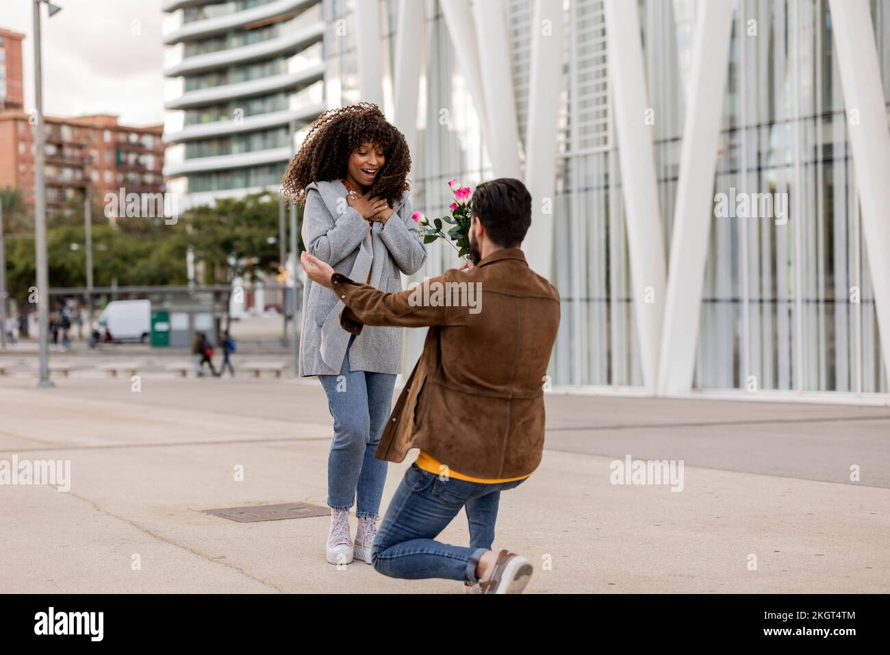 Jeune homme proposant une femme avec bouquet de fleurs sur le sentier Banque D'Images