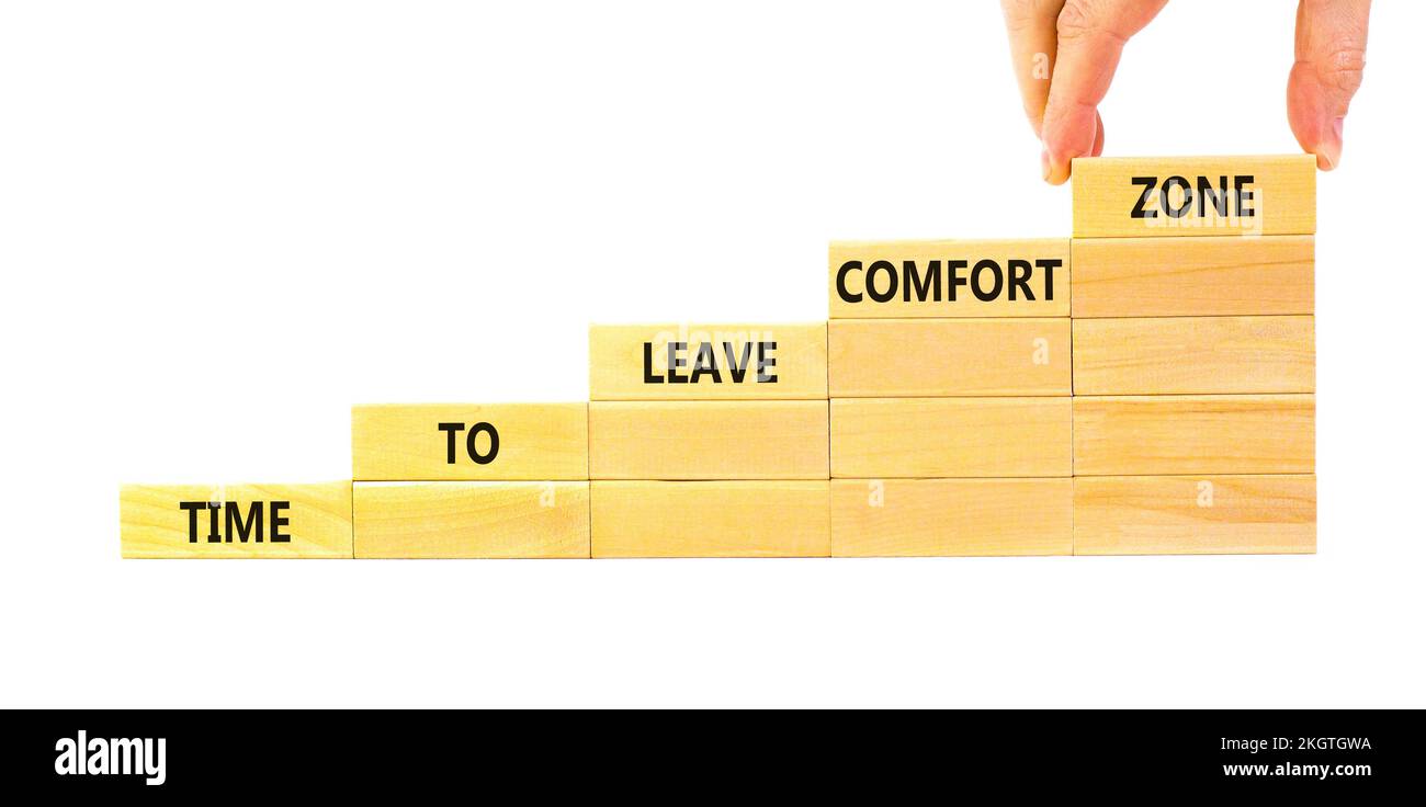 Laissez le symbole de zone de confort. Concept mots temps pour quitter la zone de confort sur des blocs de bois. Main d'homme d'affaires. Magnifique fond blanc. Temps de travail à l Banque D'Images