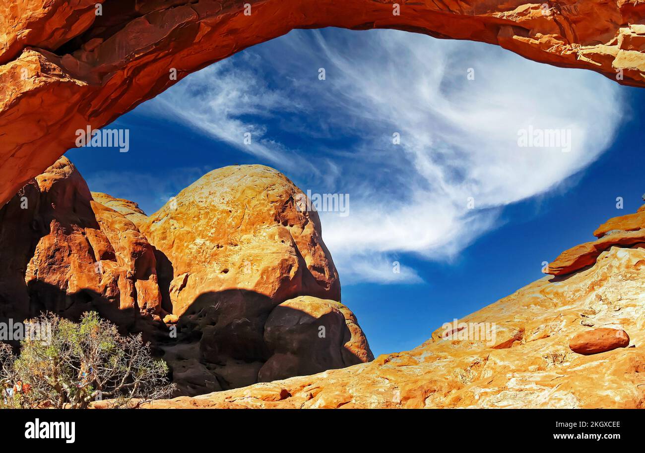 Belle fenêtre en pierre rouge isolée naturelle, ciel bleu d'été, nuage blanc moelleux - Parc national d'Arches, Utah, Etats-Unis Banque D'Images