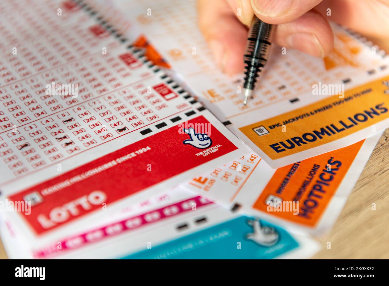 Londres. ROYAUME-UNI- 11.20.2022. Personne marquant les numéros sur un coupon de loterie. Banque D'Images