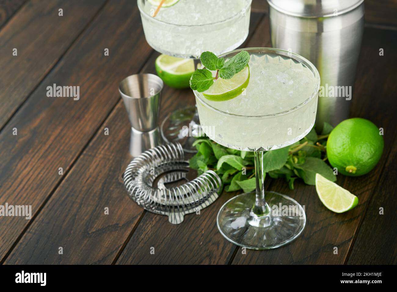 Cocktail de Margarita avec citron vert, tequila, menthe et glace sur table sombre avec rétroéclairage incroyable, espace de copie. Margarita classique ou cocktail Daiquiry. Carte à barres Banque D'Images