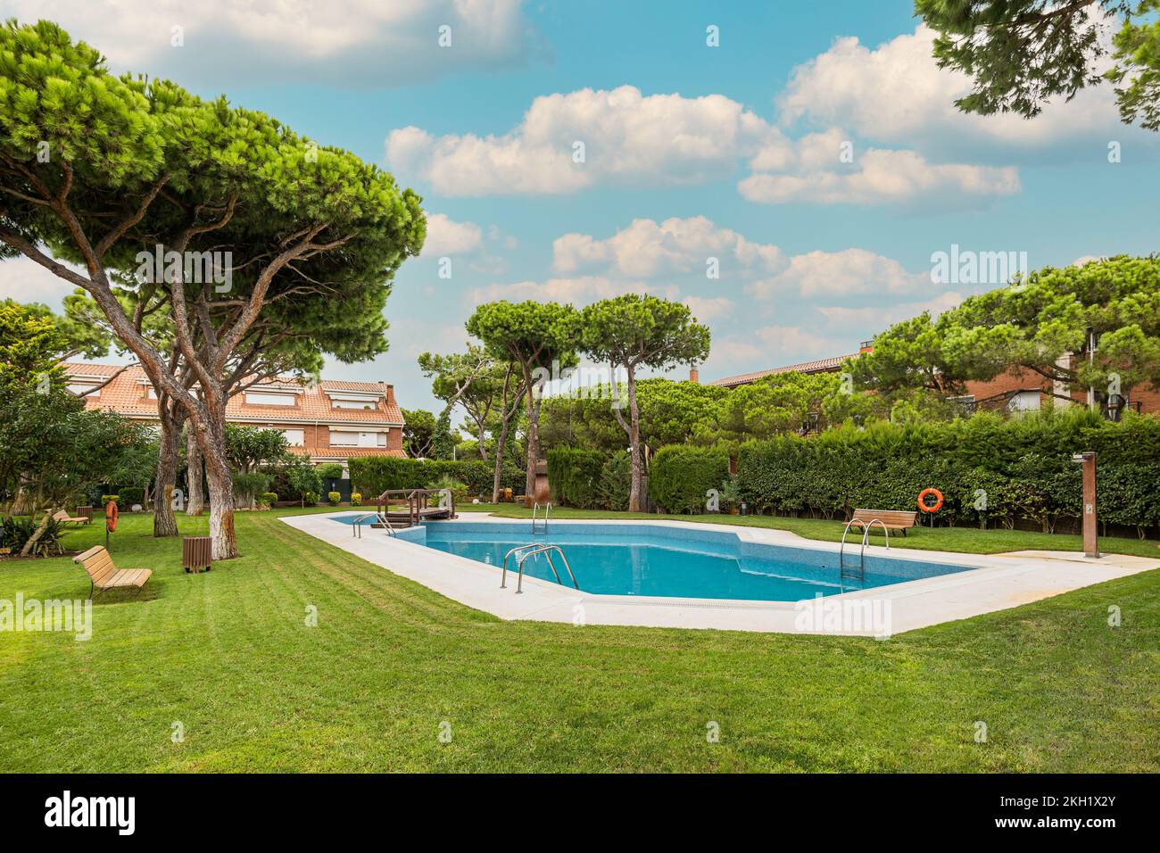 Arrière-cour de complexe résidentiel avec jardin et piscine avec arbres autour le jour ensoleillé. Banque D'Images