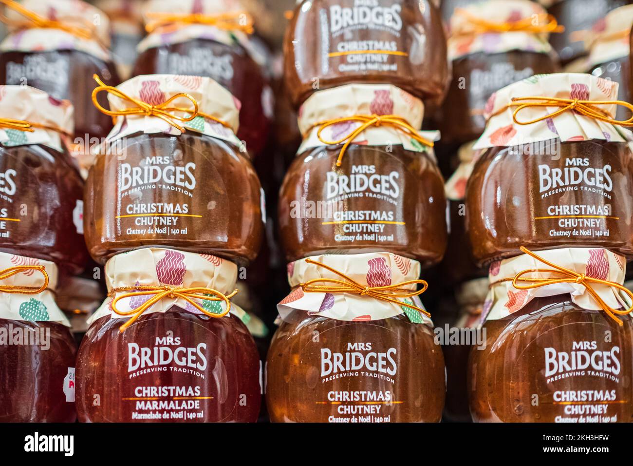 Variétés de Chutney en pots de verre pour l'hiver. Sauce pêche en conserve et chutney au piment et marmelade dans des pots en verre sur une étagère en bois, vue latérale. Personne-sur Banque D'Images