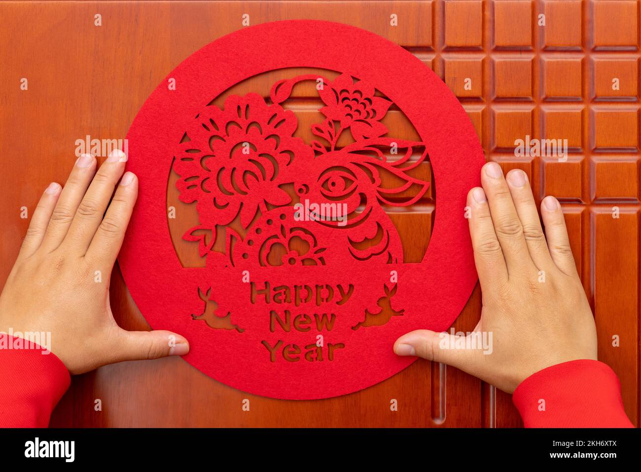 Homme collant un nouvel an chinois de papier de lapin coupé décoration à une porte à la composition horizontale Banque D'Images